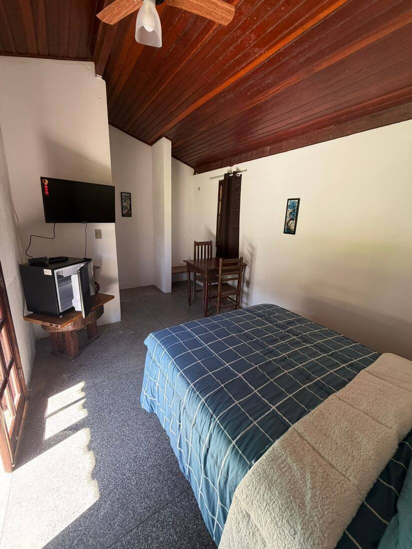 Suíte casal com TV e mesa